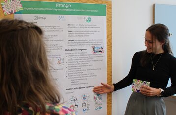 Eine Frau erklärt eine Posterwand