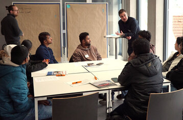Symbolic photo: a group of students in discussion with a moderator