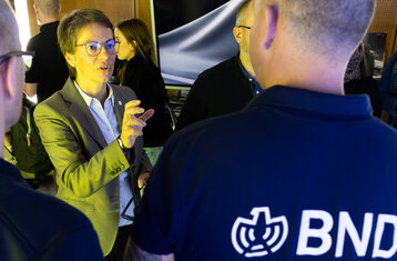 Three people in conversation at an exhibition stand
