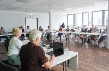 Group of people seated at a table in a conference room