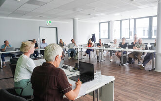 Group of people seated at a table in a conference room