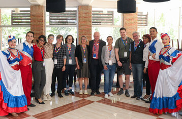 The tour group framed by people in traditional dress